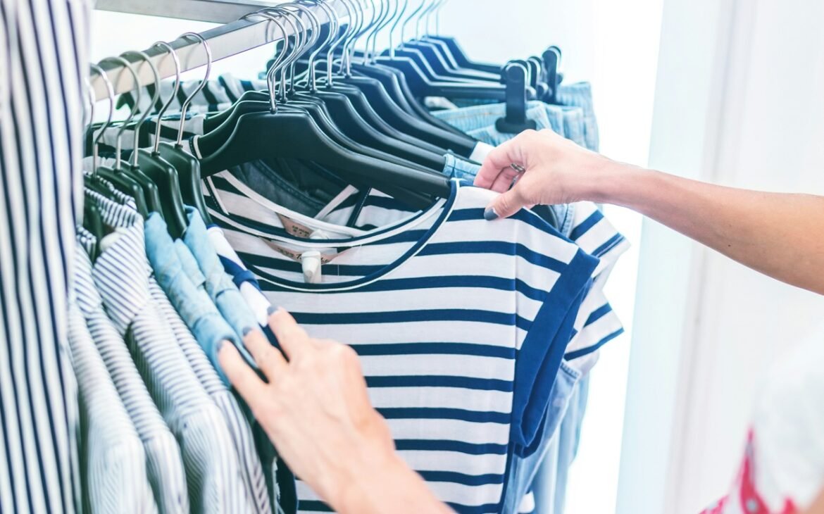 Person holding white and blue striped shirt.